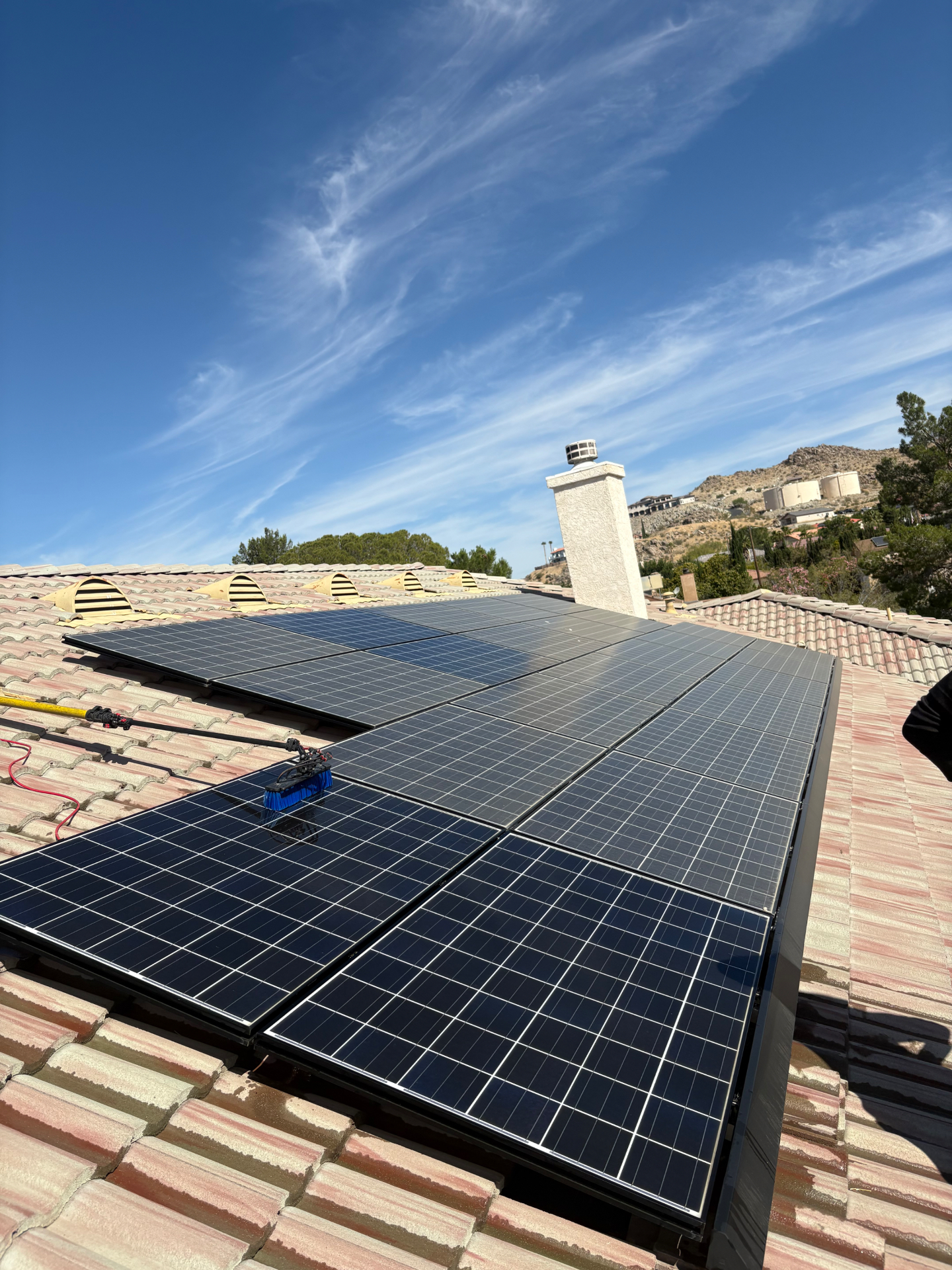 Solar panels being professionally cleaned at sunset