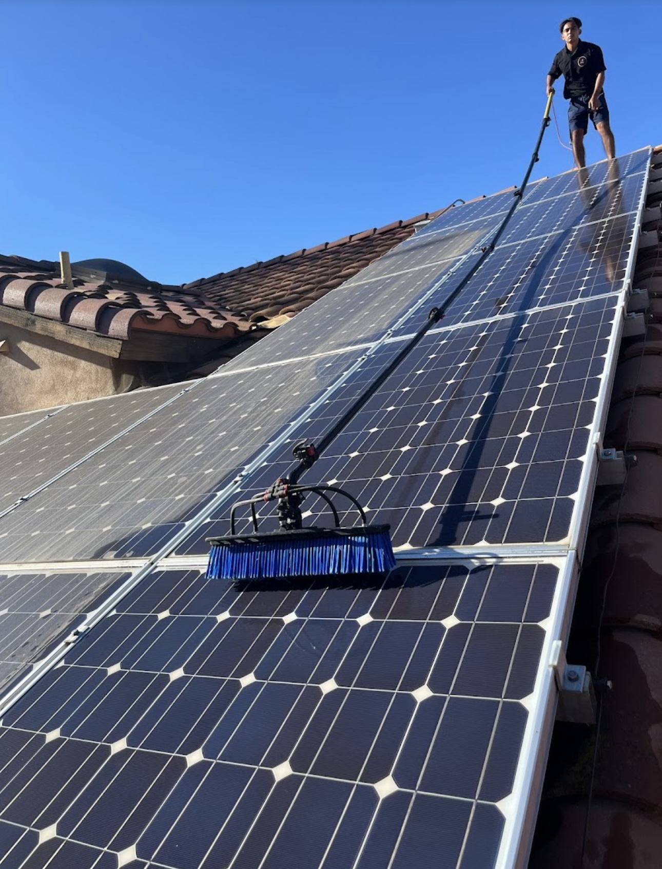 Solar panels being professionally cleaned at sunset